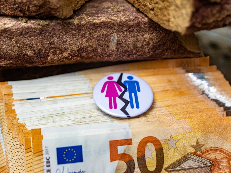 Geldscheine, Mann und Frau als Symbol für Gender-Pay-Gap